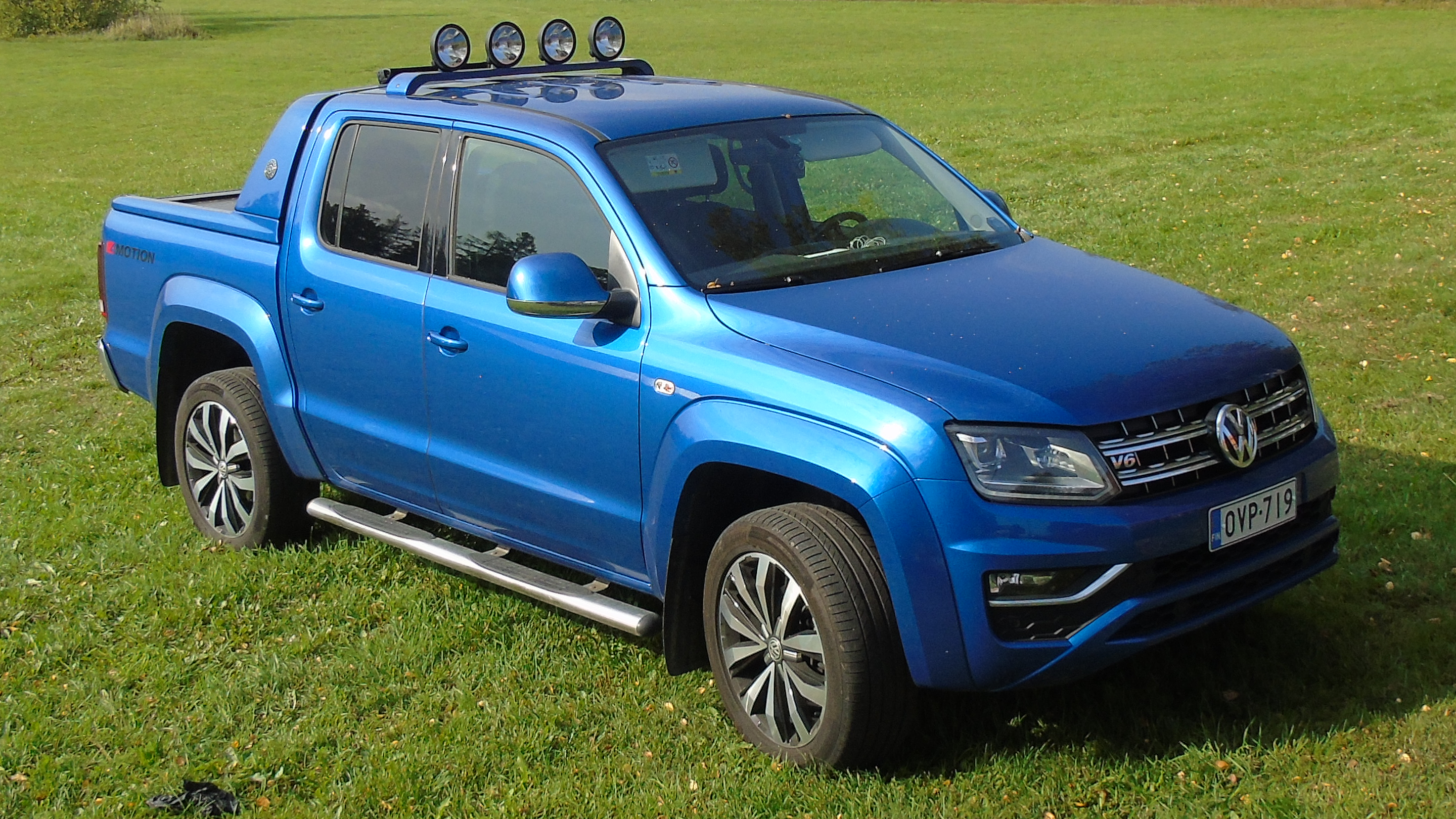 Image a of a blue Volkswagen Ammarok, parked in a field